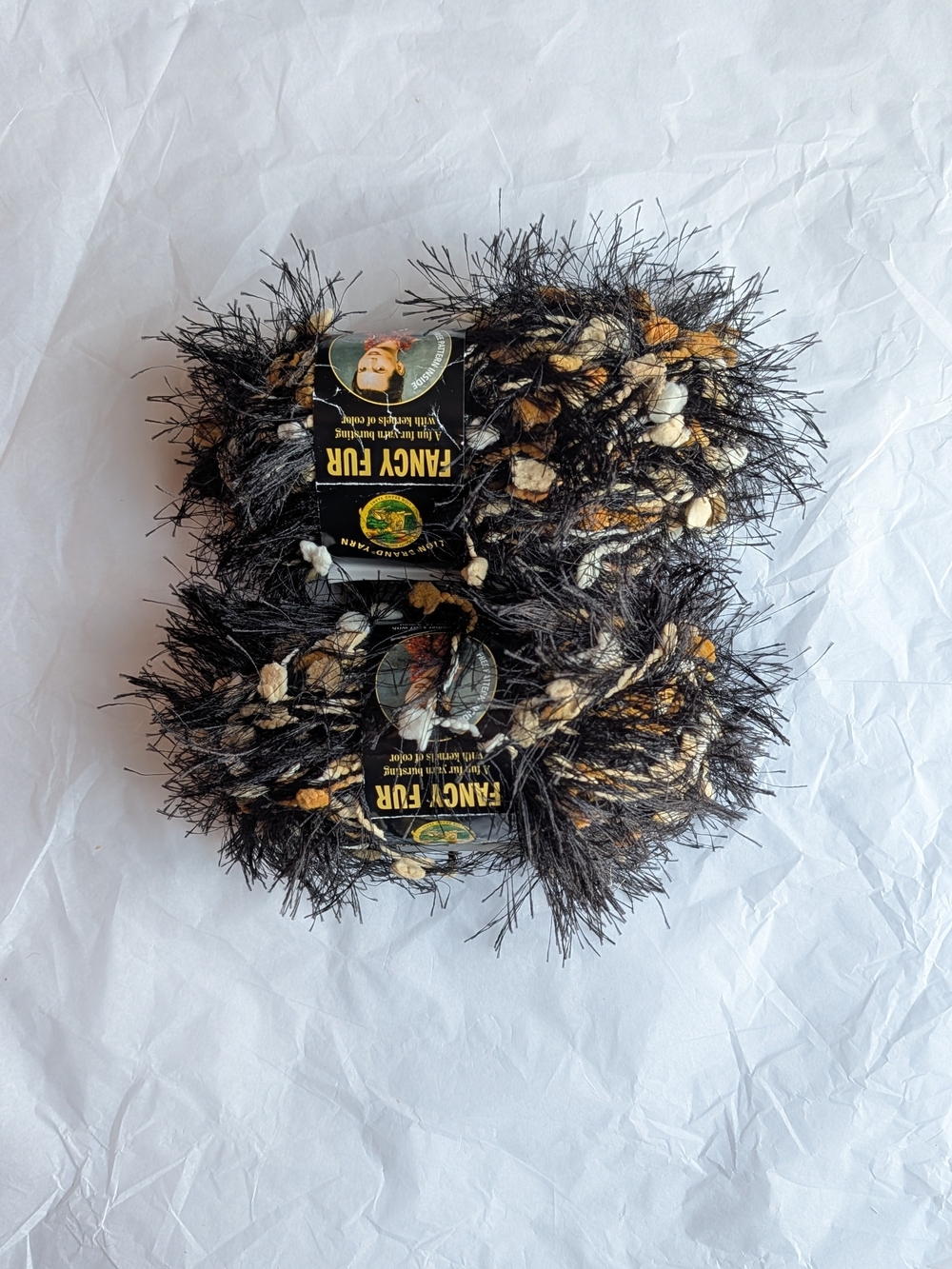 2 full skeins of Lion Brand Fancy Fur yarn in the color 'ecru & ebony'